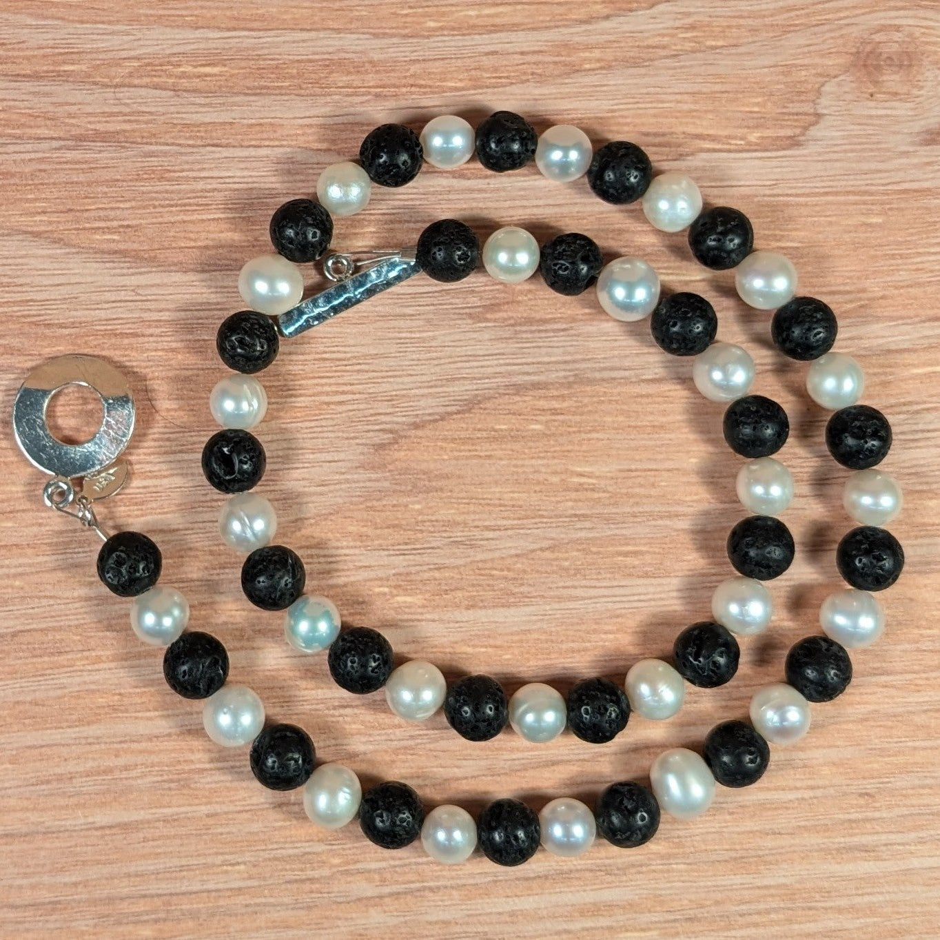 Necklace with black and white beads on a wooden surface