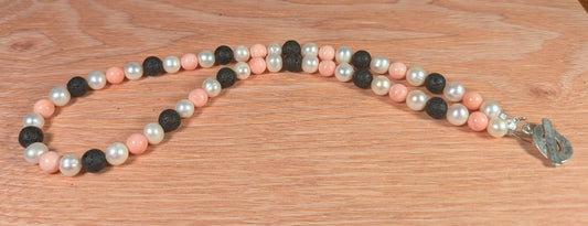 Necklace with pearls and black beads on a wooden surface