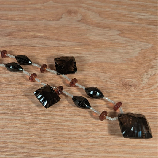 Necklace with black and red beads on a wooden surface