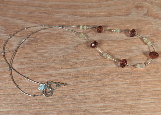 Necklace with beads and charms on a wooden surface