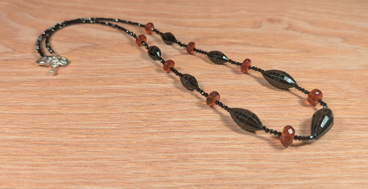 Necklace with black and red beads on a wooden surface