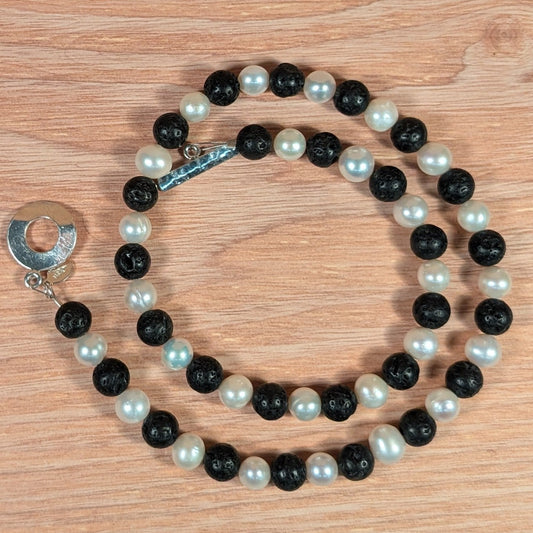 Necklace with black and white beads on a wooden surface