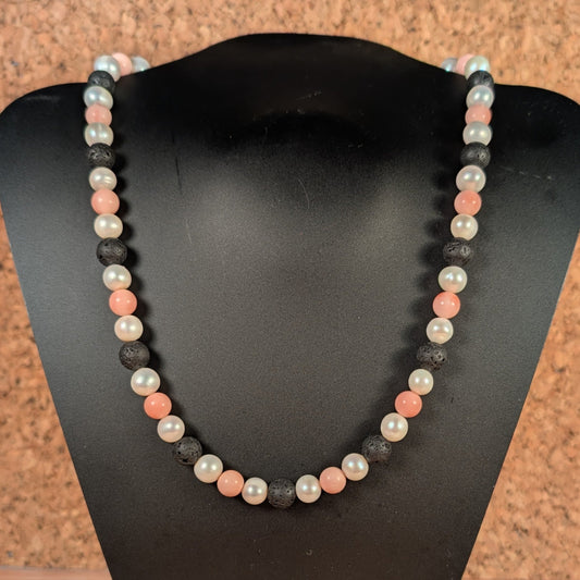Necklace with multicolored beads on a black stand against a wooden background
